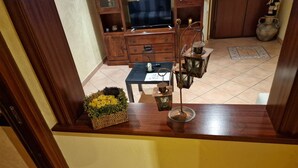 A wooden counter with a basket of yellow flowers, a metal lantern, and a black table with papers. - Two steps from the heart of Rome. (Roma)