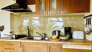 A kitchen with granite countertops, stainless steel appliances, wooden cabinets, and a coffee maker.