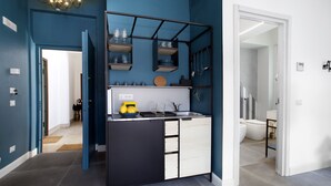 A modern kitchen with a black and white color scheme, a built-in sink, and a countertop with various kitchen items. - Design Flat (Piano di Sorrento)