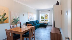 A modern living room with a sectional sofa, a dining table with chairs, and artwork on the walls. - Camelot in Oliva With 1 Bedrooms and 1 Bathrooms (Oliva)