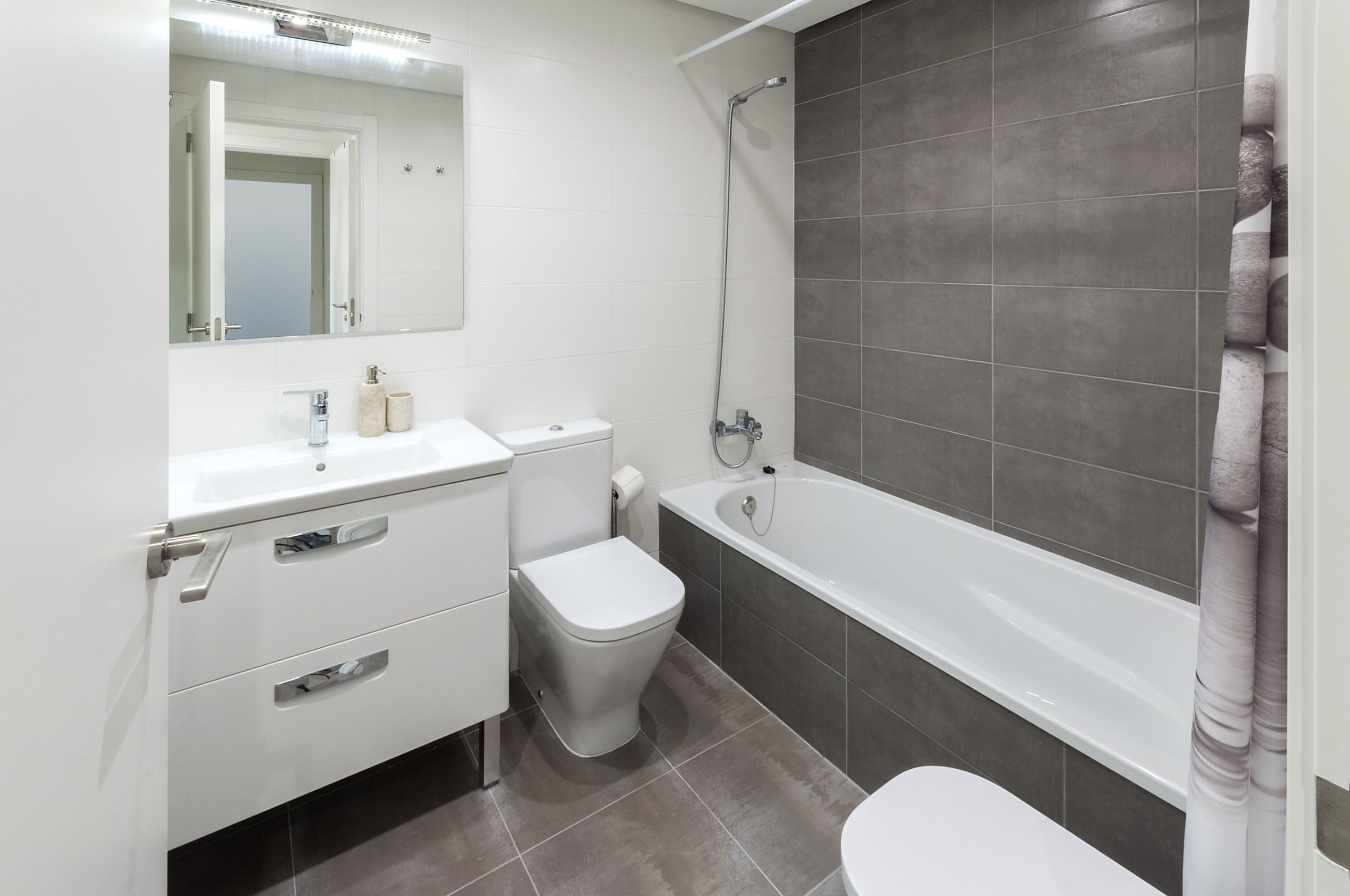 Un baño moderno con inodoro, lavamanos y bañera.