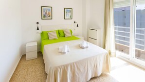 A hotel room with a bed, two nightstands, a window with a view, and artwork on the wall. - Bambu in Grau i Platja (Gandia)