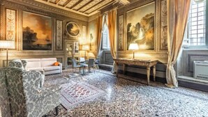 A luxurious room with a marble floor, a sofa, a table, and a painting on the wall.