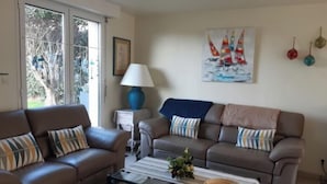 A living room with two sofas, a coffee table, a lamp, and a painting of sailboats. - Maison Presqu'ile de Gâvres (Gâvres)