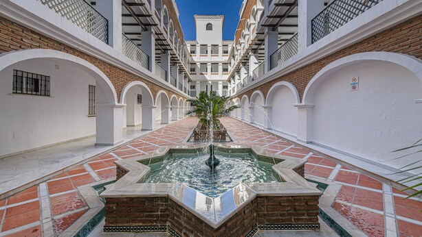 A courtyard with a central fountain, white walls, and a tiled floor. - Benalmar Playa in Benalmadena (Benalmádena)