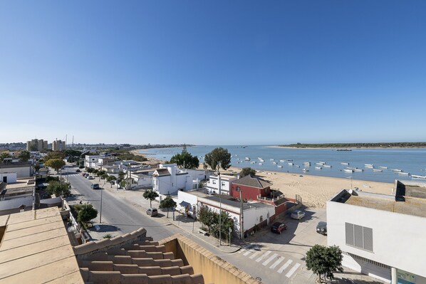 A coastal town with a beach, boats, and buildings.