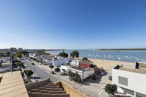 A coastal town with a beach, boats, and buildings.