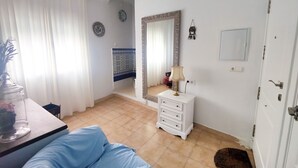 A bedroom with a bed, a dresser, a mirror, and a window with curtains. - Altamar in Conil de la Frontera (Conil de la Frontera)