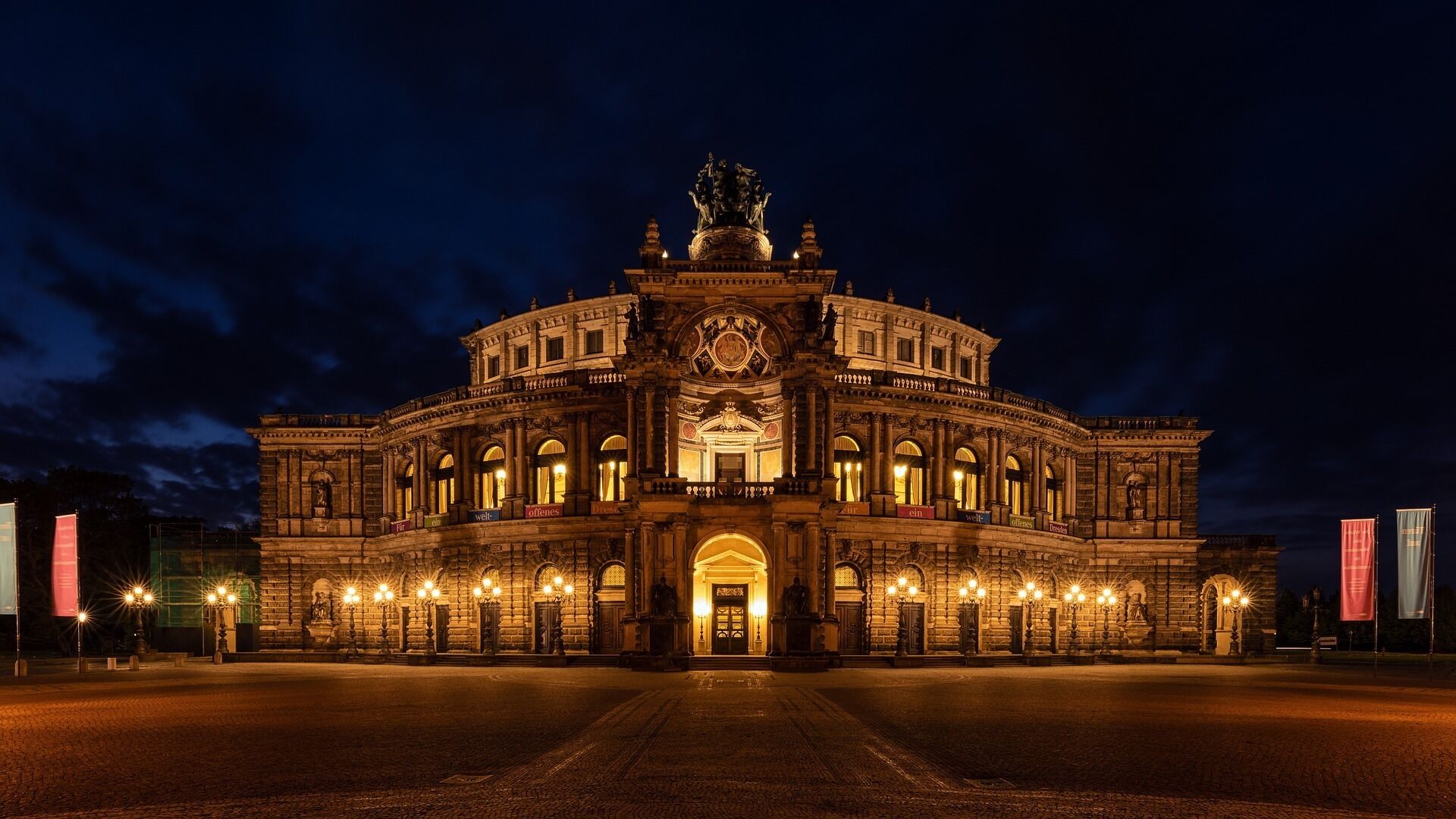 A grand, historic building with a central dome and ornate facade, featuring multiple arched windows and a prominent entrance.