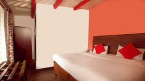 Ein Schlafzimmer mit einem hölzernen Bett, roten Kissen und einer Holzbank.