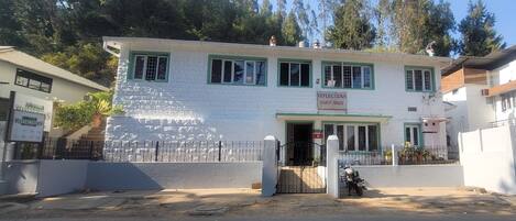 A two-story building with a sign reading "Reflections Guest House".
