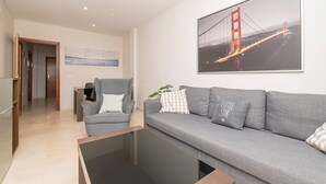 Un soggiorno moderno con un divano grigio, un tavolino da caffè e un quadro di un ponte.