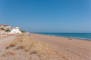 A beach with a clear sky, a sandy shore, and buildings in the background. - Cascades in D nia With 2 Bedrooms and 1 Bathrooms (Denia)