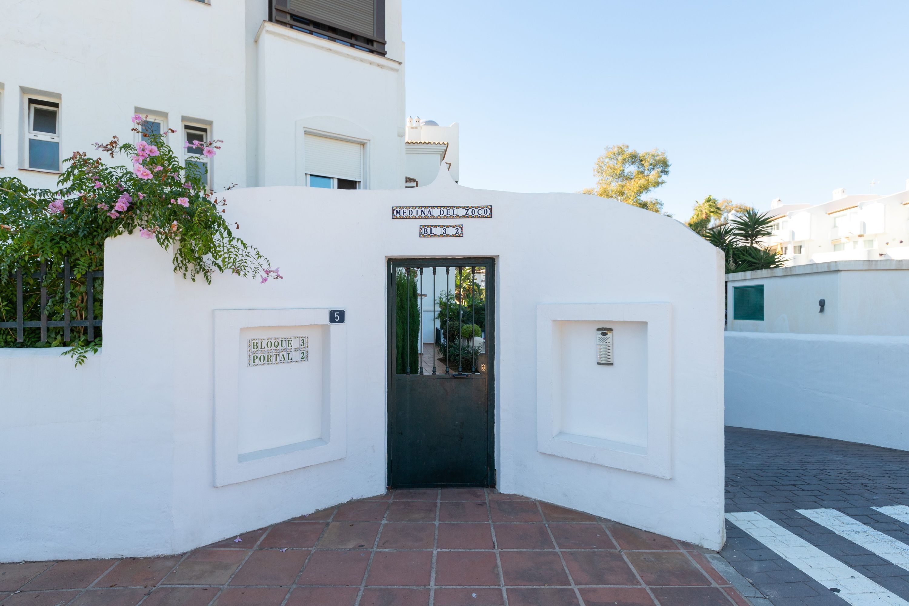 A white building with a sign reading "MEDINA DEL ZOCO BL 32".