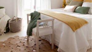 A bedroom with a bed, a chair, a table, a hanging light, and a window with curtains. - Casa Tecolote in Chiclana de la Frontera (Chiclana de la Frontera)
