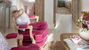 A cozy living room with a plush red armchair, a wooden coffee table, and a view into another room through a wooden door. - Casa Tecolote in Chiclana de la Frontera (Chiclana de la Frontera)