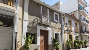 A row of buildings with balconies, potted plants, and a 'For Sale' sign. - Casc Antic in Javea With 2 Bedrooms and 1 Bathrooms (Javea)