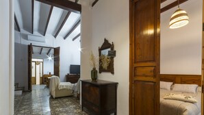 A room with a patterned floor, a wooden cabinet, a bed with patterned bedding, and a hanging light fixture. - Casc Antic in Javea With 2 Bedrooms and 1 Bathrooms (Javea)