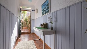 A hallway with a white table, a green tray, and a vase with flowers. - Casa Del Olivo in Algeciras (Algeciras)