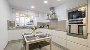 A modern kitchen with white cabinets, a built-in microwave, and a stainless steel oven. - Casa Del Olivo in Algeciras (Algeciras)