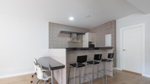 A compact kitchen with a dining area, featuring a modern design with patterned wallpaper, a built-in stove, and a small refrigerator. - Clipper in Alhaurin de la Torre (Alhaurin de la Torre)