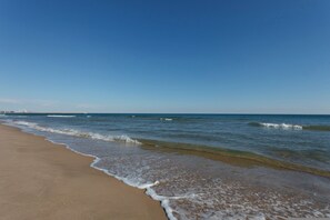 A beach with clear blue water and a sandy shore. - Odisea in Piles With 3 Bedrooms and 2 Bathrooms (Piles)