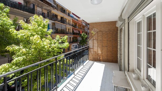 A balcony with a metal railing, a white table, and a window with white curtains. - Samba in Gandia With 3 Bedrooms and 1 Bathrooms (Gandia)