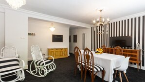 A dining area with a white table, striped chairs, and a chandelier. - Samba in Gandia With 3 Bedrooms and 1 Bathrooms (Gandia)