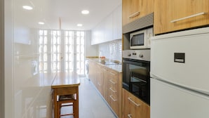 A modern kitchen with wooden cabinets, a white refrigerator, a microwave, and a sink. - Turia in Tavernes de la Valldigna (Tavernes de la Valldigna)