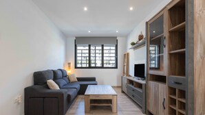 Un salon moderne avec un canapé d’angle, une table basse et des étagères encastrées en bois.