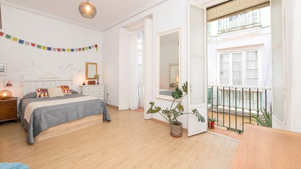A bedroom with a bed, bedside table, lamp, and a potted plant. - Starlight in Cadiz With 3 Bedrooms and 1 Bathrooms (Cádiz)