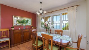 Un coin repas avec une table en bois, des chaises et un vase de fleurs.