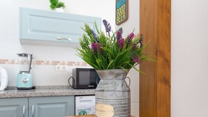 A kitchen with light blue cabinets, a vintage metal vase with a label, and a wooden table. - Tolox 1 in Tolox With 1 Bedrooms and 1 Bathrooms (Tolox)
