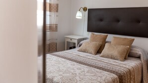 A neatly made bed with patterned bedding, a bedside lamp, and a dark headboard. - Tolox 1 in Tolox With 1 Bedrooms and 1 Bathrooms (Tolox)
