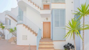 A multi-story building with a central staircase, a wooden door, and a small balcony. - Villablanca Home in Villablanca (Villablanca)