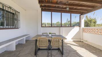 Enjoy a peaceful outdoor space with a table, chairs, and bench, offering a view of lush greenery.