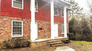 A two-story brick building with a red exterior and white trim.