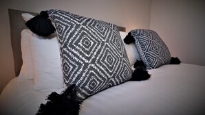 A bed with a patterned blanket and two black tassels. - Connelly House - Motherwell (Motherwell)