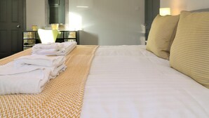 Een hotelkamer met een bed, een bureau, een stoel en een lamp.