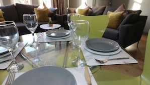 Een eethoek met een tafel gedekt voor vier personen, inclusief borden, glazen en bestek.