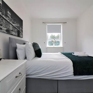 A bedroom with a bed, white dresser, and a window with a view of trees. - Kirkhill Middle - Lanark (Lanark)