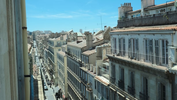 Une rangée de bâtiments historiques dotés de balcons, sous un ciel dégagé.