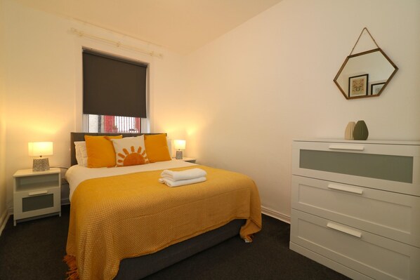 A neatly arranged bedroom with a bed, bedside tables, a dresser, and a wall-mounted mirror. - Glen Lee - Bellshill (Bellshill)