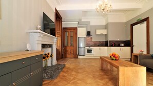 Una cocina moderna con horno empotrado, un comedor con mesa de madera y una sala de estar con sofá.
