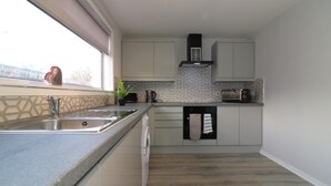 Egy modern konyha beépített mosogatógéppel, kilátással rendelkező ablakkal és mintás csempeburkolattal.