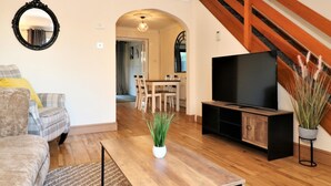 A living room with a sofa, a coffee table, a TV, and a staircase. - Shield House - Govan (Glasgow)