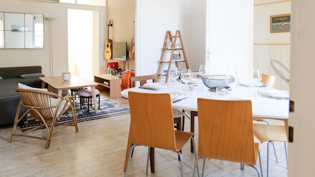 A spacious living area with a dining table set for four, surrounded by wooden chairs. A guitar and a ladder are visible in the background. - Holiday home quartier Arago Les Sables - 8 people (Les Sables-d´Olonne)