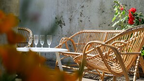 Wicker furniture with a table and chairs, a potted plant, and a concrete wall. - Holiday home quartier Arago Les Sables - 8 people (Les Sables-d´Olonne)