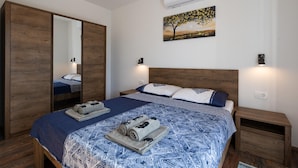 Une chambre à coucher avec un grand lit, une armoire, un tableau au mur et une table de chevet.
