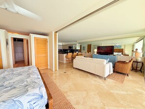 Habitación de hotel con cama, sofá, zona de comedor y cocina.